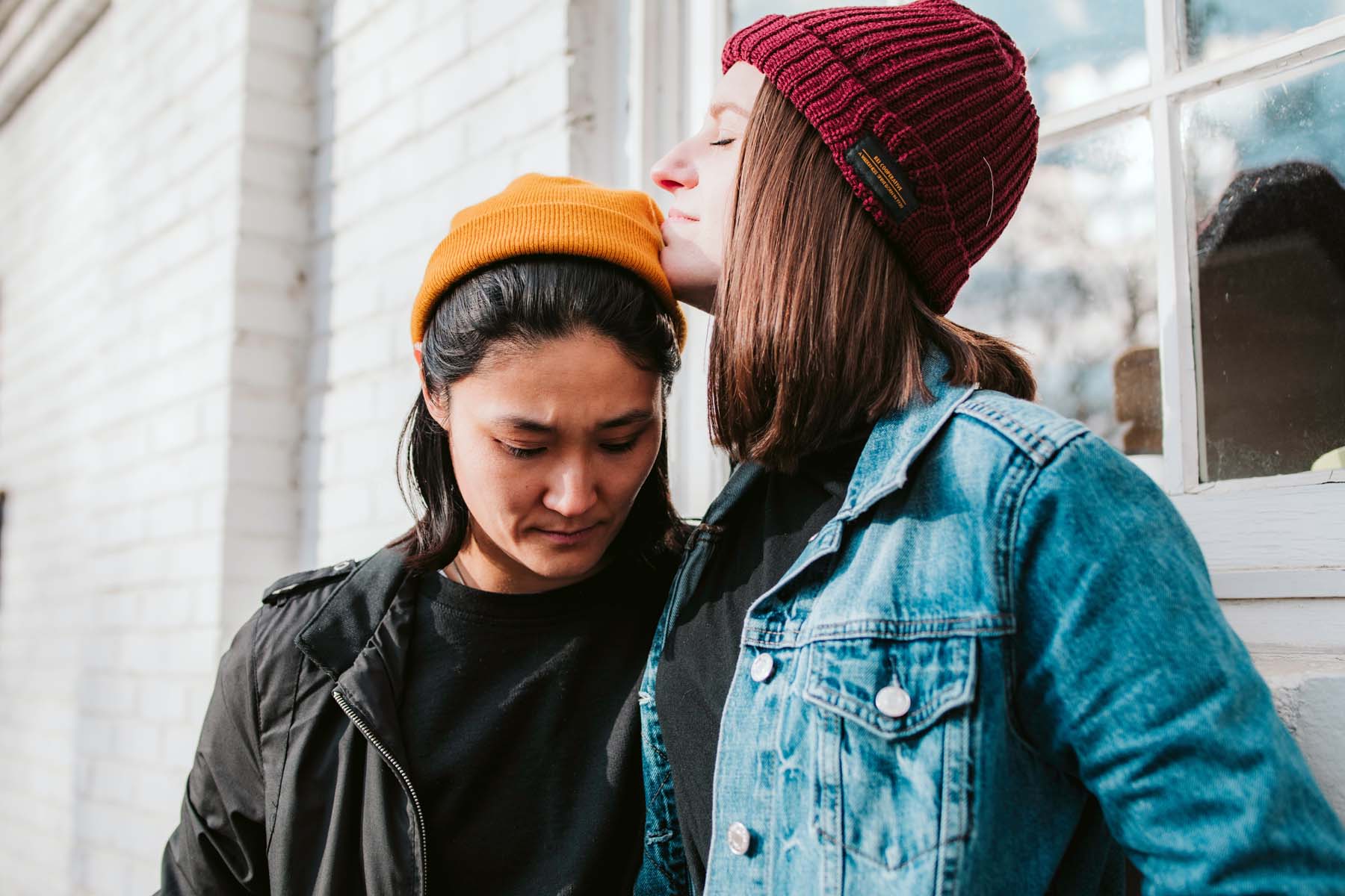 One person comforting another by a window — support through relationship difficulties